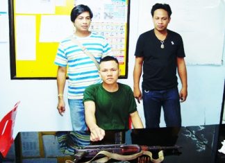 Worawut Langlorm (seated) points to the AK-47 he tried to sell over the Internet.